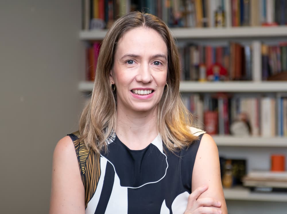 Maria Sílvia Logatti, psicóloga, diante de uma estante de livros